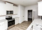Thumbnail 6 of 11 - 3 Bedroom Homes for rent in Crowley TX- Lasater Ranch - An interior shot of the kitchen, featuring stainless steel appliances, marble counter tops, and white cabinets