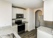 Thumbnail 22 of 33 - a kitchen with granite counter tops and white cabinets
