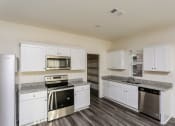Thumbnail 9 of 32 - an empty kitchen with white cabinets and stainless steel appliances