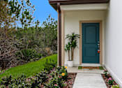 Thumbnail 35 of 56 - A house with a blue door and a green plant in front.