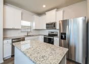 Thumbnail 2 of 23 -  3 Bedroom single family homes for rent in fort Worth, TX- Oak Ridge - An interior shot of the kitchen, featuring stainless steel appliances, white cabinetry, and an island