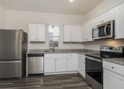 Thumbnail 28 of 32 - an empty kitchen with stainless steel appliances and white cabinets