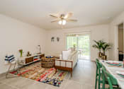 Thumbnail 6 of 56 - A living room with a white couch, a rug, and a ceiling fan.