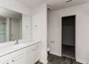 Thumbnail 13 of 33 - an empty bathroom with a large mirror and a white vanity with a sink and toilet