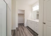 Thumbnail 12 of 32 - a bathroom with white cabinets and a sink and a shower