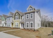 Thumbnail 1 of 19 - a row of houses in a neighborhood with a blue sky in the background
