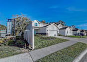 Thumbnail 18 of 21 - a row of houses on a street with a blue sky in the background