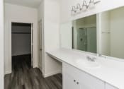 Thumbnail 20 of 32 - a bathroom with a sink and a mirror and a closet