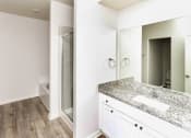 Thumbnail 22 of 23 - A bathroom with a marble countertop and a large mirror.