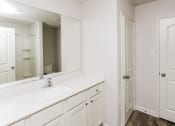 Thumbnail 31 of 33 - a bathroom with white cabinets and a sink and a mirror