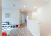 Thumbnail 21 of 56 - A room with a white wall and a painting hanging on it.