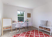 Thumbnail 18 of 56 - A white room with a red rug and a white table with chairs.