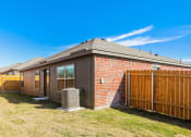 Thumbnail 33 of 33 - Newark TX Single Family Homes for Rent - Chisholm Springs - Brick House with Grassy Lawn, Large Windows, and a Wooden Fence