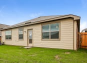 Thumbnail 23 of 23 - a tan house with a yard and a wooden fence