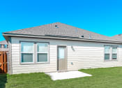 Thumbnail 14 of 32 - Haslet TX Houses For Rent - Willow Springs - The Back Of A House With A Lawn And Covered Porch Area