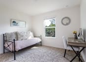 Thumbnail 16 of 56 - A bedroom with a bed, desk, and window.