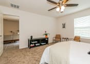 Thumbnail 15 of 56 - A bedroom with a large bed, a ceiling fan, and a chair.