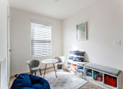 Thumbnail 12 of 56 - A room with a blue bean bag chair and a white chair with a small table between them.