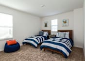 Thumbnail 10 of 56 - Two twin beds with blue and white striped bedspreads in a room with two blue bean bag chairs.