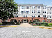 Thumbnail 30 of 32 - A large building with a parking lot in front of it.