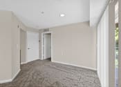 Thumbnail 11 of 32 - A room with a carpeted floor and two doors.
