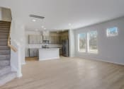 Thumbnail 17 of 19 - an empty living room and kitchen with a staircase in the background