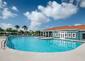 Thumbnail 2 of 28 - A large swimming pool with a building next to it.