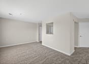 Thumbnail 10 of 32 - A room with a carpeted floor and a door on the right side.
