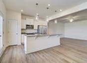 Thumbnail 8 of 20 - a kitchen and living room with a large island