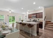 Thumbnail 5 of 28 - Omnia at Richmond Hill Townhomes in Georgia photo of a kitchen and dining area with a table and chairs and a counter top