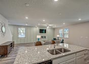 Thumbnail 7 of 21 - a kitchen with an island and a living room in the background