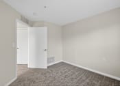 Thumbnail 15 of 32 - A room with a carpeted floor and two white doors.