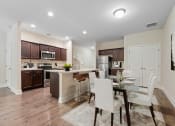 Thumbnail 6 of 28 - Omnia at Richmond Hill Townhomes in Georgia photo of a kitchen and dining room with a table and chairs