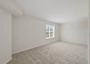 Thumbnail 13 of 32 - A room with a carpeted floor and a window.