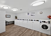 Thumbnail 26 of 32 - A laundromat with a row of washers and dryers.