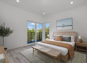 Thumbnail 6 of 23 - a bedroom with a bed and a sliding glass door to a balcony
