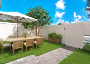 Thumbnail 2 of 23 - a backyard patio with a table and chairs and a grill