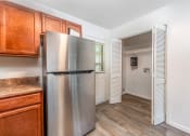 Thumbnail 10 of 17 - a kitchen with a stainless steel refrigerator and wooden cabinets