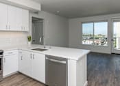 Thumbnail 3 of 20 - A kitchen with white cabinets and a black stove top oven.