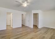 Thumbnail 7 of 20 - a bedroom with hardwood floors and white walls