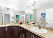 Thumbnail 9 of 12 - One K Apartments in Atlanta, GA photo of a bathroom with two sinks and a mirror