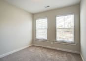Thumbnail 19 of 25 - an empty room with two windows and a carpeted floor