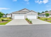 Thumbnail 60 of 62 - a house with a white garage door in front of a driveway