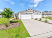 Thumbnail 1 of 62 - a house with a driveway and a garage door in front of it