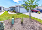 Thumbnail 52 of 62 - a house with a driveway and a tree in front of it