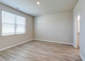 Thumbnail 9 of 62 - an empty living room with wood flooring and a window