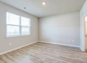 Thumbnail 56 of 62 - an empty living room with wood flooring and a window
