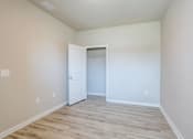 Thumbnail 6 of 62 - a bedroom with white walls and a closet with a door