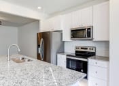 Thumbnail 6 of 45 - a kitchen with granite counter tops and stainless steel appliances