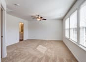 Thumbnail 26 of 45 - an empty living room with large windows and a ceiling fan
